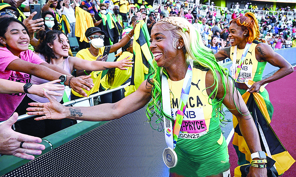 EUGENE: Gold medalist Jamaica's Shelly-Ann Fraser-Pryce (left) and bronze medalist Jamaica's Elaine Thompson-Herah shake hands with spectators after the women's 100m final during the World Athletics Championships at Hayward Field in Eugene.- AFP