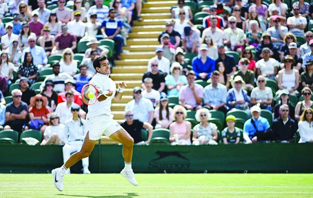 WIMBLEDON: Chile's Cristian Garin returns the ball to Australia's Alex De Minaur during their round of 16 men's singles tennis match on the eighth day of the 2022 Wimbledon Championships on July 4, 2022. - AFP