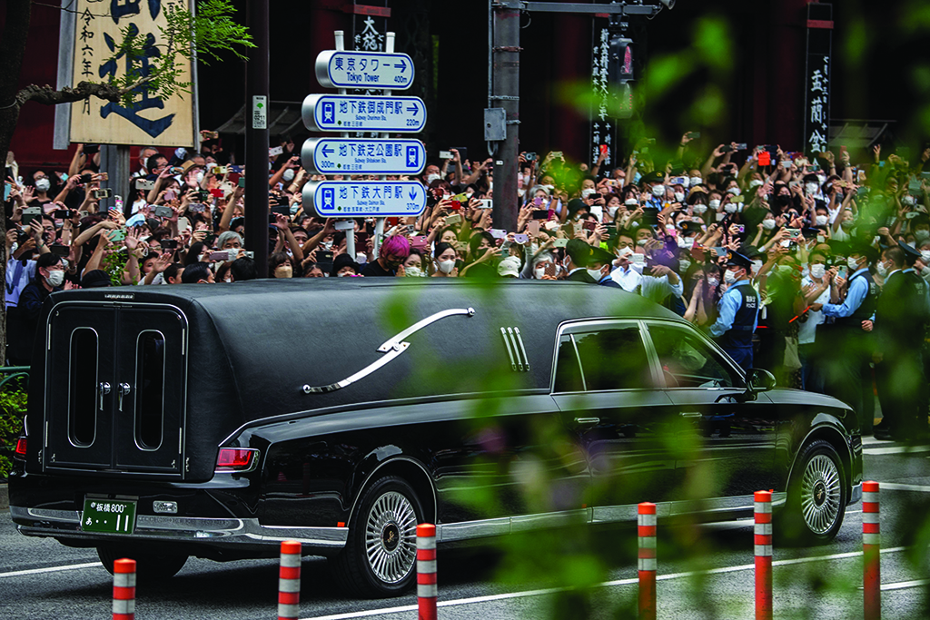 TOKYO: People watch the hearse transporting the body of late former Japanese prime minister Shinzo Abe as it leaves Zojoji Temple on July 12, 2022. - AFP