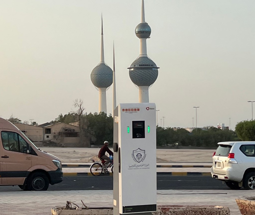 Electric charging post with the iconic Kuwait Towers in the background.<br>