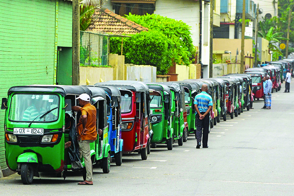 COLOMBO: Auto rickshaw drivers and motorists queue along streets to buy fuel at fuel stations on July 3, 2022. - AFP