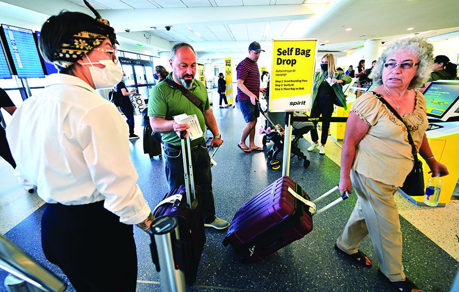 Travellers check in on the depatures level at Los Angeles International Airport (LAX) on July 1, 2022, ahead of the July 4th holiday weekend. - US airlines are bracing customers for what will probably be another bumpy holiday weekend as the industry struggles to manage a surge in travel demand that probably exceeds its current capacity. (Photo by Frederic J. BROWN / AFP)