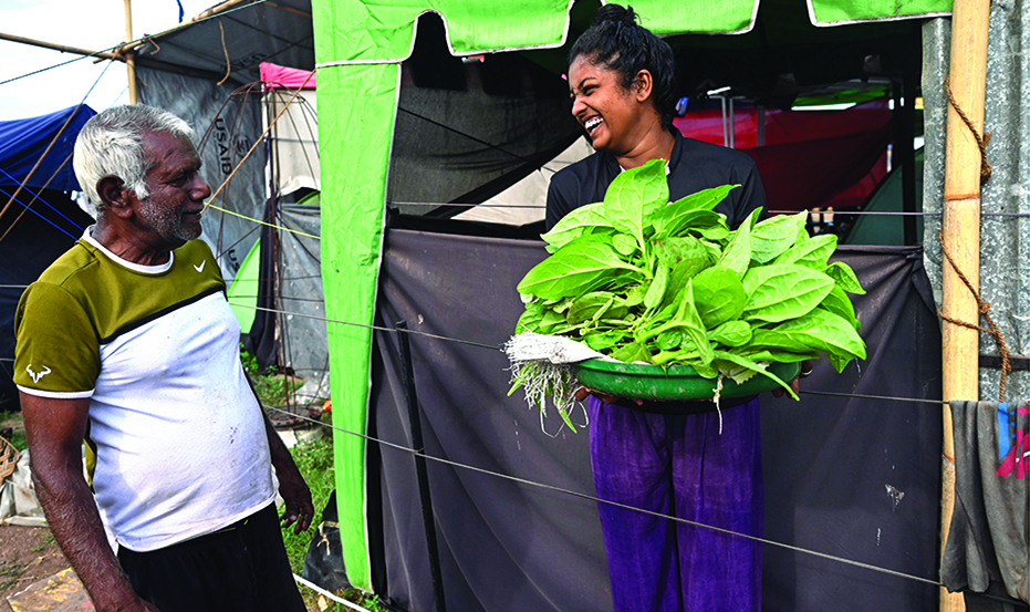 COLOMBO, Sri Lanka: This photo taken on July 17, 2022 shows an activist holding vegetables grown by Theodore Rajapakse (left) in his garden at the Galle Face protest site in Colombo, where he teaches others how to produce fast-growing vegetables in small patches of land near their homes. - AFP