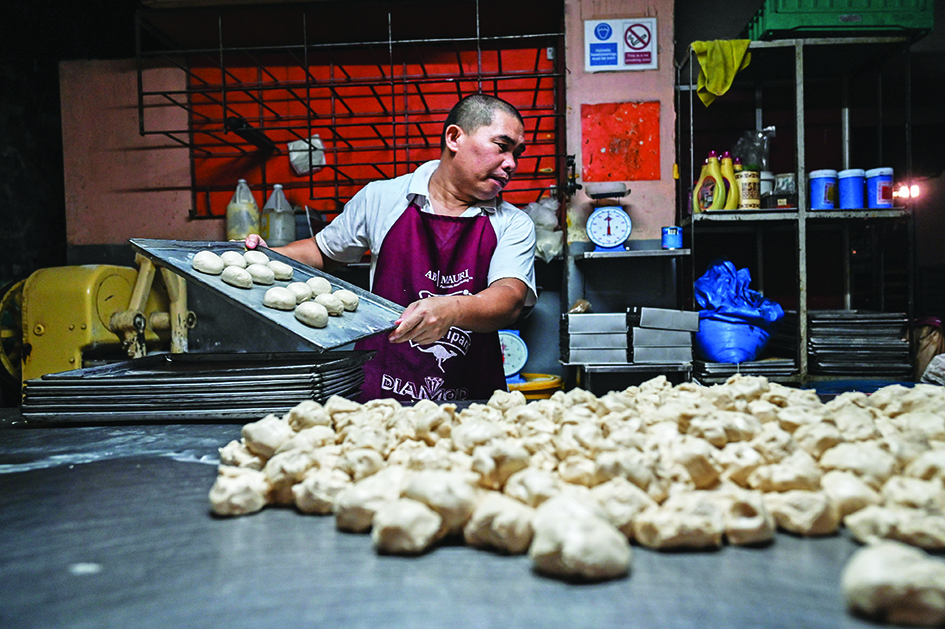 MANILA: In this photo taken on July 20, 2022, a baker prepares dough for the popular breakfast roll 'pandesal' at a bakery in Manila. - AFP