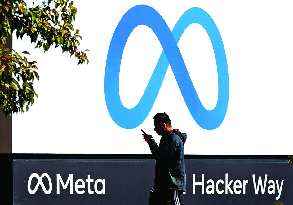 MENLO PARK: A pedestrian walks in front of a new logo and the name 'Meta' on the sign in front of Facebook headquarters in Menlo Park, California. US market regulators on July 27, 2022, went to court to stop Meta from buying virtual reality fitness app maker Within, a potential blow to the tech giant's metaverse ambitions. - AFP