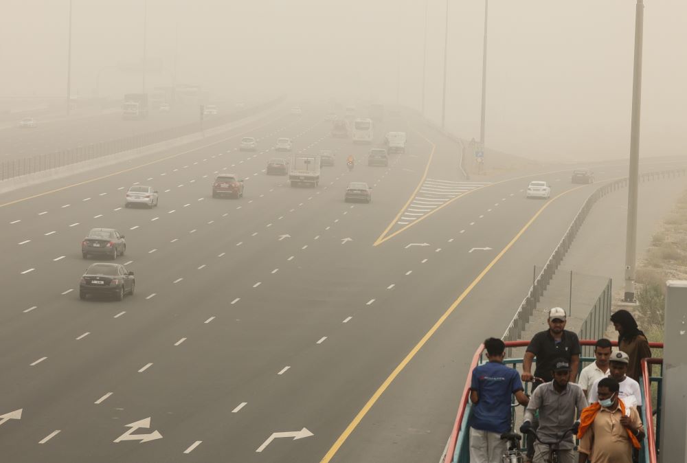 DUBAI: People walk up the stairs toward a bridge during a sand storm in the Gulf emirate of Dubai, on August 14, 2022. -- AFP