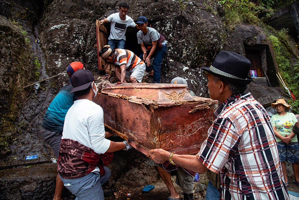 Members of the Toraja ethnic group exhuming bodies of their relatives from a community burial site, to be cleaned and dressed in a series of traditional ceremonies honoring the dead known as 