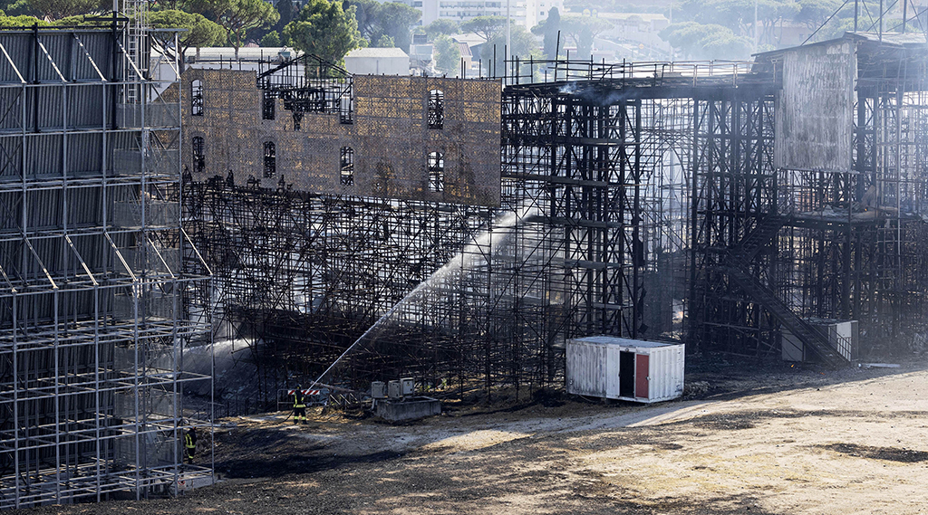 Firefighters hose down a structure to extinguish a fire at the Cinecitta studios southeast of Rome. — AFP photos