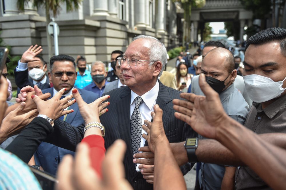 Putrajaya: Malaysia's former prime minister Najib Razak (C) greets supporters as he walks out during a break in the trial during an appeal against his corruption conviction over the 1MDB financial scandal, at the federal court in Putrajaya, on August 23, 2022. - AFP