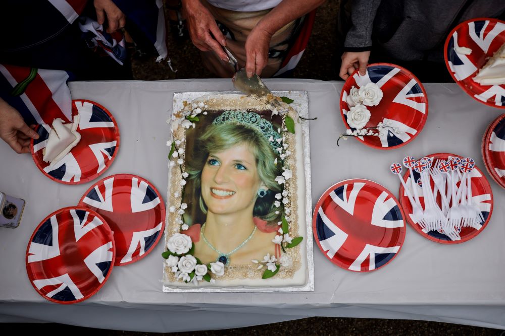 LONDON: Visitors cut a cake depicting late Britain's Princess Diana in front of Kensington Palace, in central London, on August 31, 2022. - AFP