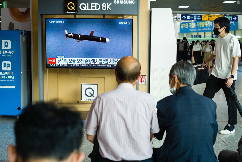 SEOUL: People sit near a screen showing a news broadcast with file footage of a North Korean missile test, at a railway station in Seoul on August 17, 2022, after North Korea fired two cruise missiles, Seoul's defence ministry said. – AFP