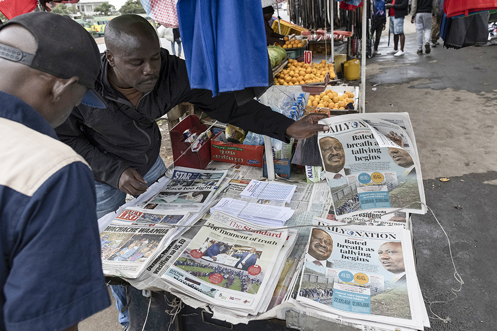 NAIROBI, Kenya: A newspaper vendor arranges newspapers that headlines electoral news following Kenya's general election at a newsstand in Nairobi on August 10, 2022.— AFP