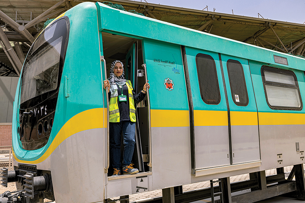 CAIRO: Hind Omar, an Egyptian metro train driver, poses on a life-size train simulator at Adly Mansour station in Heliopolis on May 31, 2022. - AFP