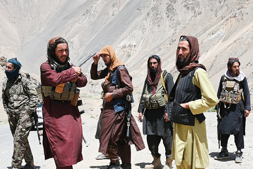 This photo taken on July 8, 2022 shows Taleban fighters standing along a road in Paryan district of Panjshir province. – AFP
