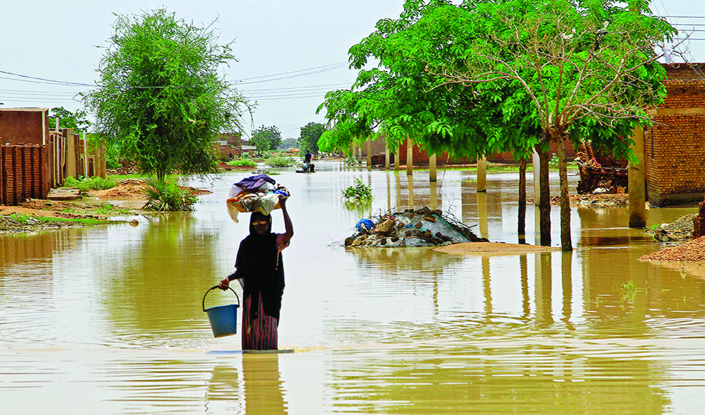 MAKAYLAB, Sudan: A woman wades through floodwater in this village in River Nile state on Aug 23, 2022. - AFP