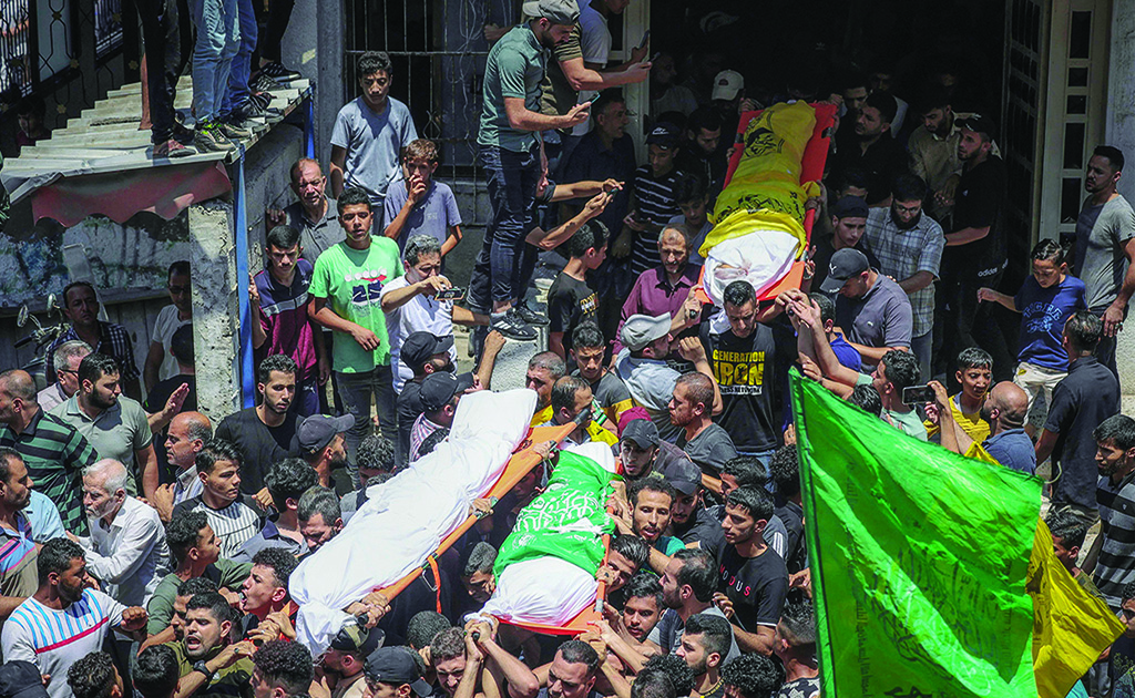 GAZA: Palestinians carry the bodies of four teenage Palestinians from the Najm family, during their funeral in Jabalia in the northern Gaza Strip on August 8, 2022, after they were killed during the latest three days of conflict between Zionists and Palestinian militants before a ceasefire. - AFP