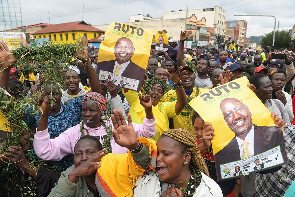 ELDORET, Kenya: Residents hold posters of Kenya's Deputy President and presidential candidate of Kenya Kwanza (Kenya First) political party coalition William Ruto while they watch a live broadcast as they wait for the results of Kenya's national election in Eldoret. - AFP