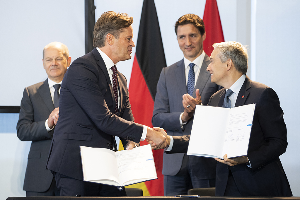 TORONTO, Canada: German Chancellor Olaf Scholz (left) and Canadian Prime Minister Justin Trudeau (right) watch as Volkswagen AG's CEO Herbert Diess (second left) shakes hands with Canadian Minister of Innovation, Science and Industry, Francois-Philippe Champagne, after signing a Memorandum of Understanding at the Canadian-German Chamber of Industry and Commerce in Toronto, Ontario, Canada, on Tuesday, August 23, 2022. - AFP