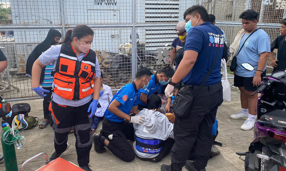 This handout photo taken and released on August 20, 2022 by the Philippine Quick Response System shows people receiving medical attention after getting hurt in a crush for educational cash aid ahead of the reopening of schools, in Zamboanga City