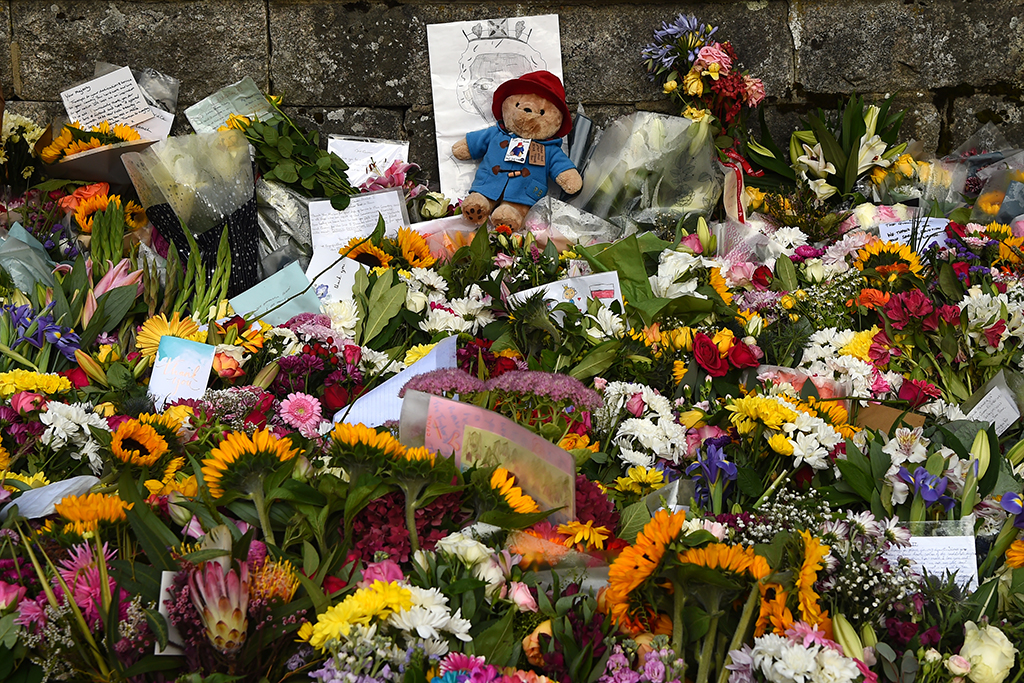 A Paddington Bear teddy bear is pictured with floral tributes in Green Park, near Buckingham Palace.