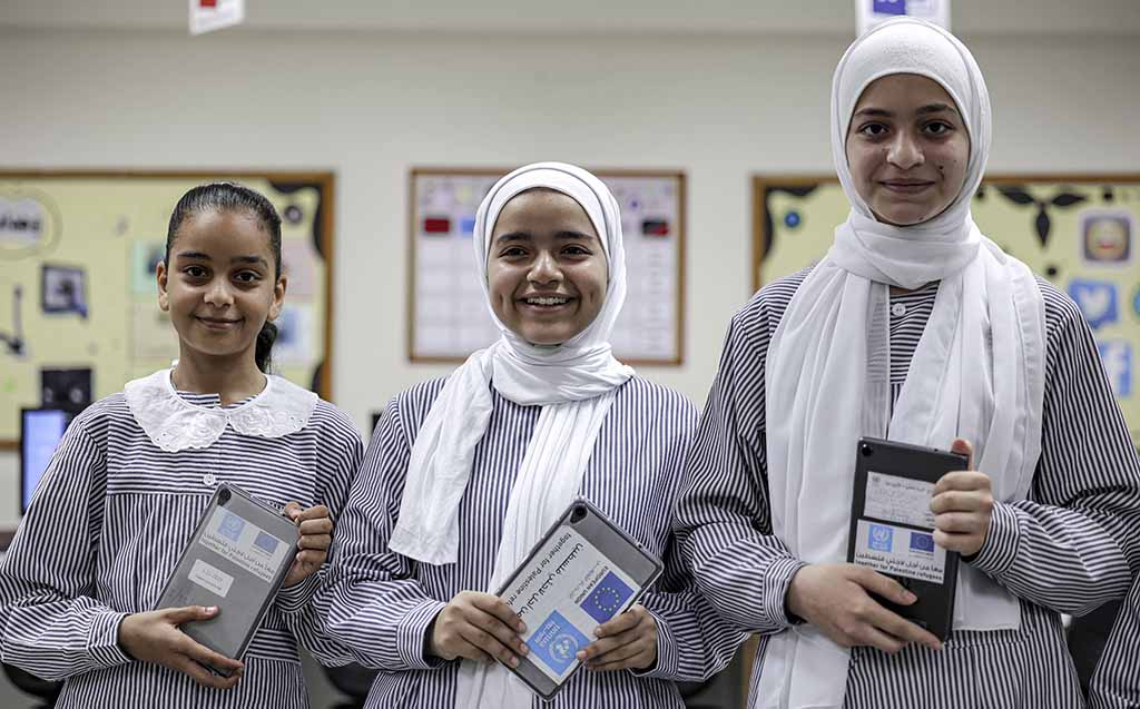 Students at a school run by the United Nations Relief and Works Agency for Palestine Refugees (UNRWA) pose with new electronic tablets in class, in Gaza City.- AFP photos