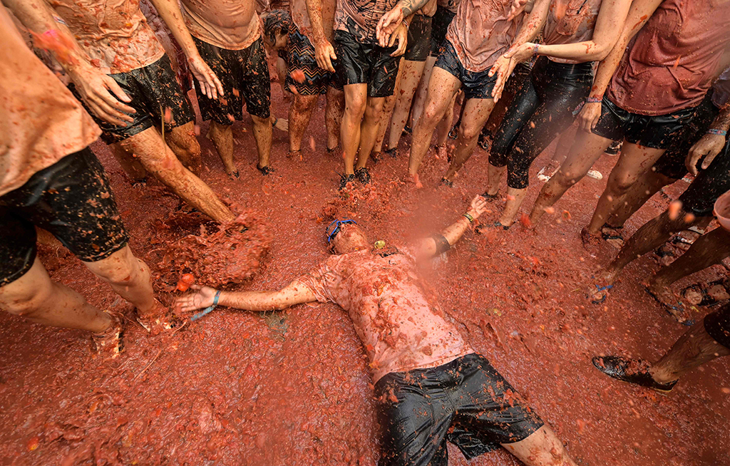 Revelers covered in tomato pulp take part in the annual “Tomatina” festival in the eastern town of Bunol. — AFP n