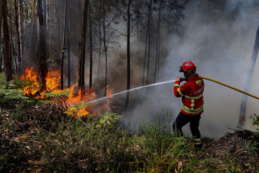 A firefighter battles a blaze at Espite in Ourem, Portugal on July 13, 2022. - AFP