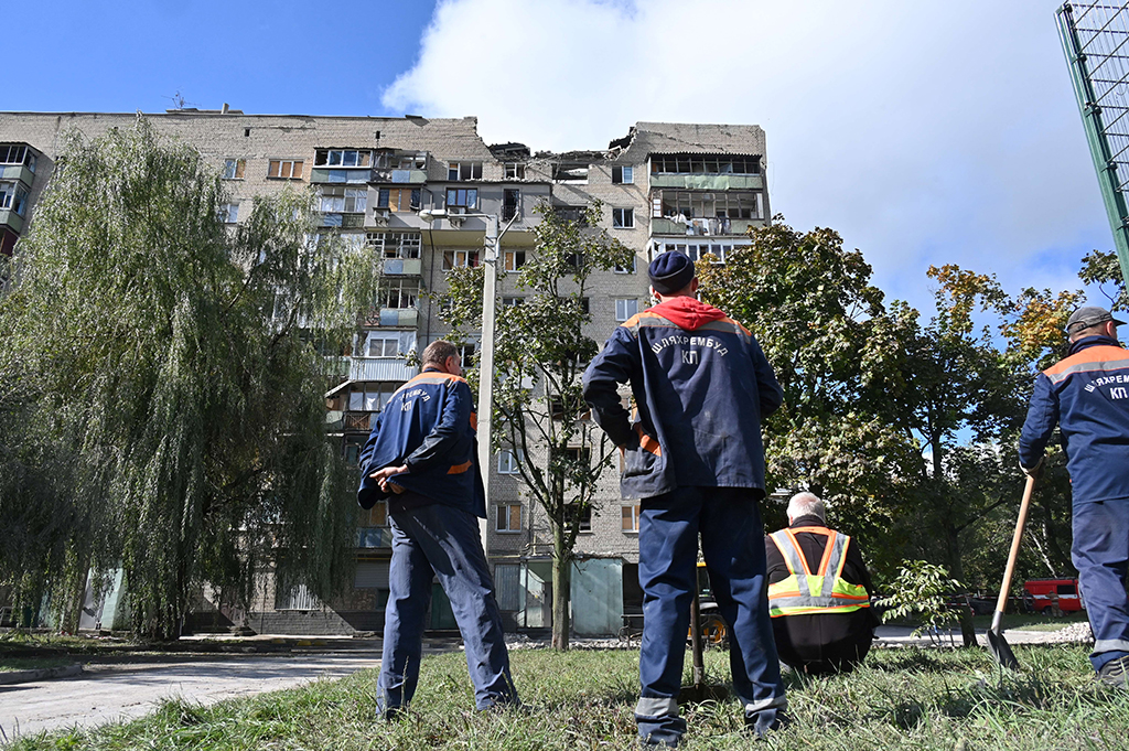 KHARKIV, Ukraine: Communal workers look at a residential building damaged after shelling in Kharkiv on September 21, 2022, amid Russian invasion of Ukraine. – AFP