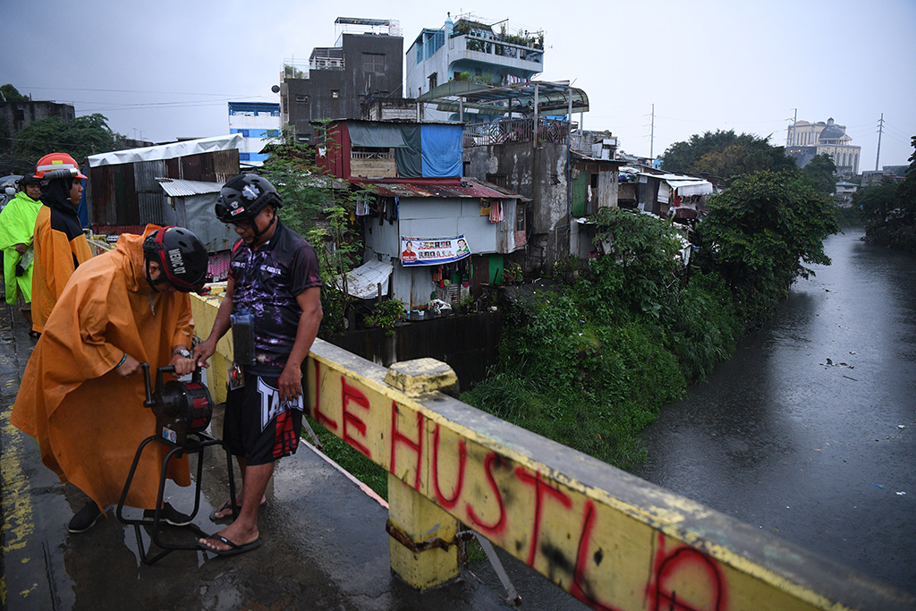 QUEZON CITY, Philippines: Village officers operate a siren to warn residents near a creek in Quezon city suburban Manila on September 25, 2022, as Super Typhoon Noru slammed into the Philippines. - AFP