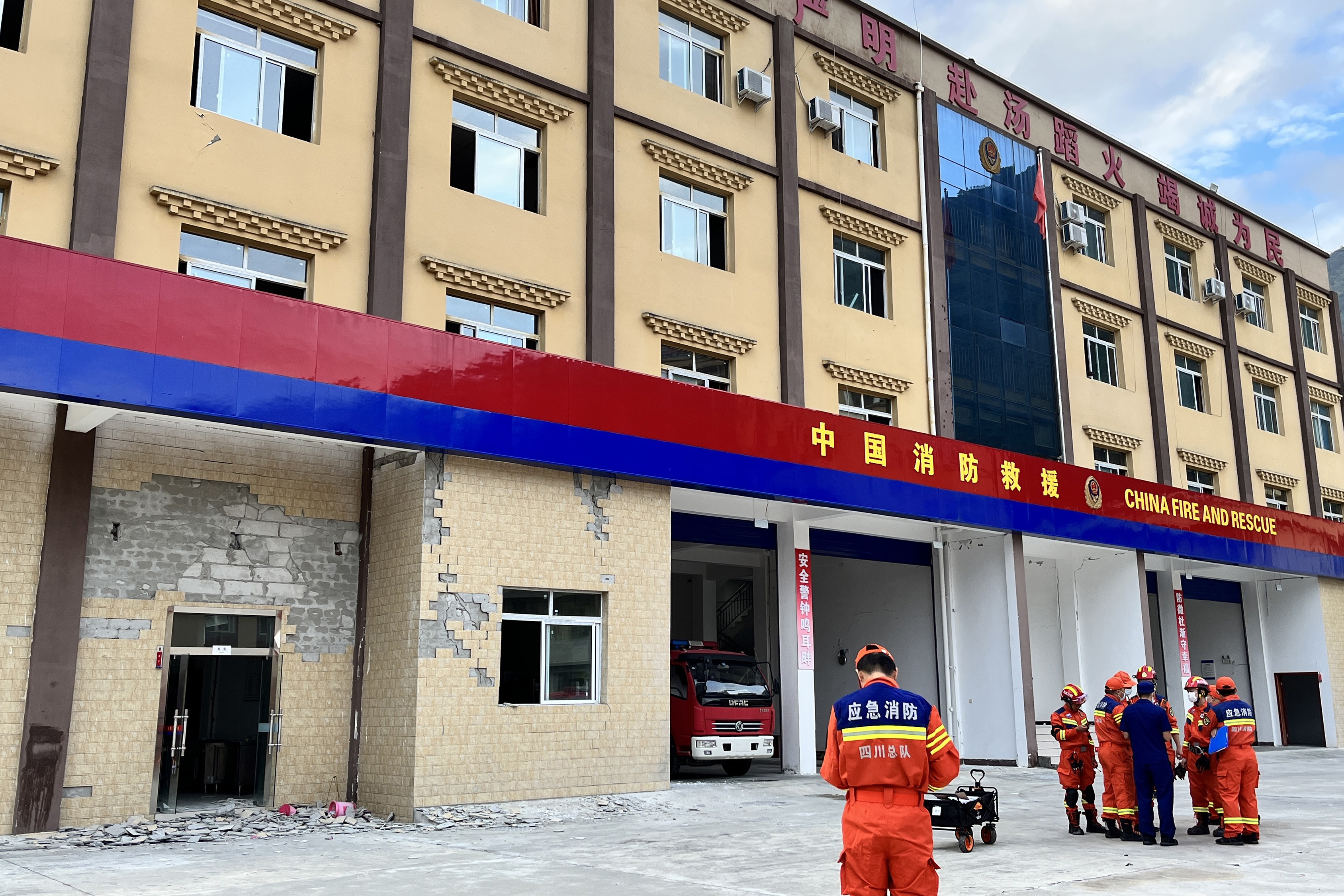 Firefighters gather near a damaged wall of a fire station after a 6.6-magnitude earthquake in Hailuogou in China's southwestern Sichuan province on September 5, 2022. (Photo by STR / AFP) / China OUT / CHINA OUT
