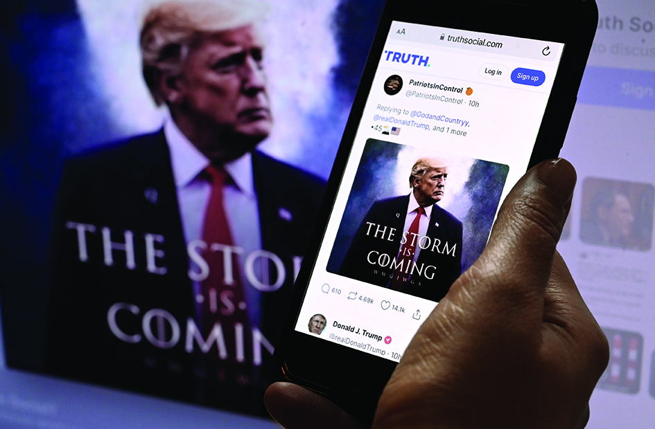 ASHINGTON, United States: In this photo illustration, Donald Trump's TRUTH Social account is seen on a mobile device with an image of former US president Donald Trump in the background in Washington. - AFP