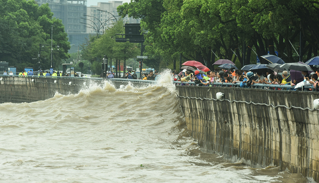 HANGZHOU, China: People watch waves generated by Typhoon Muifa breaking along the coast in Hangzhou in China's eastern Zhejiang province. – AFP
