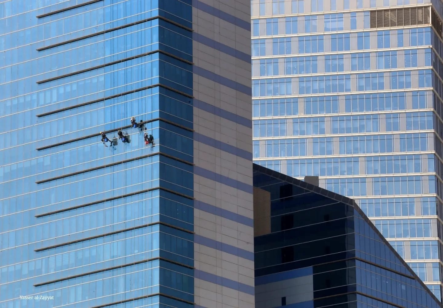 KUWAIT: Workers clean the windows of a high-rise building in Kuwait City. — Photo by Yasser Al-Zayyat.n