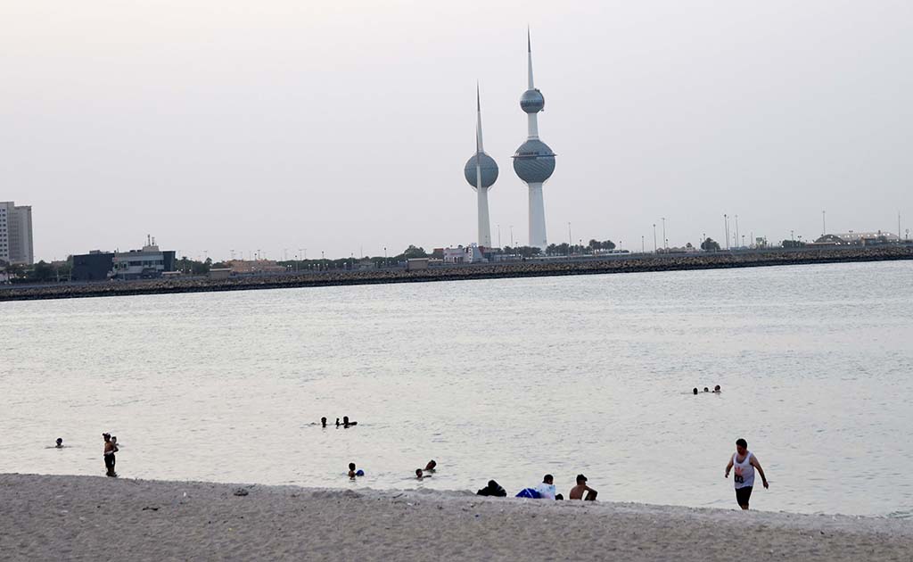 KUWAIT: People cool off at the beach near Kuwait Towers. – Photo by Fouad Al-Shaikh