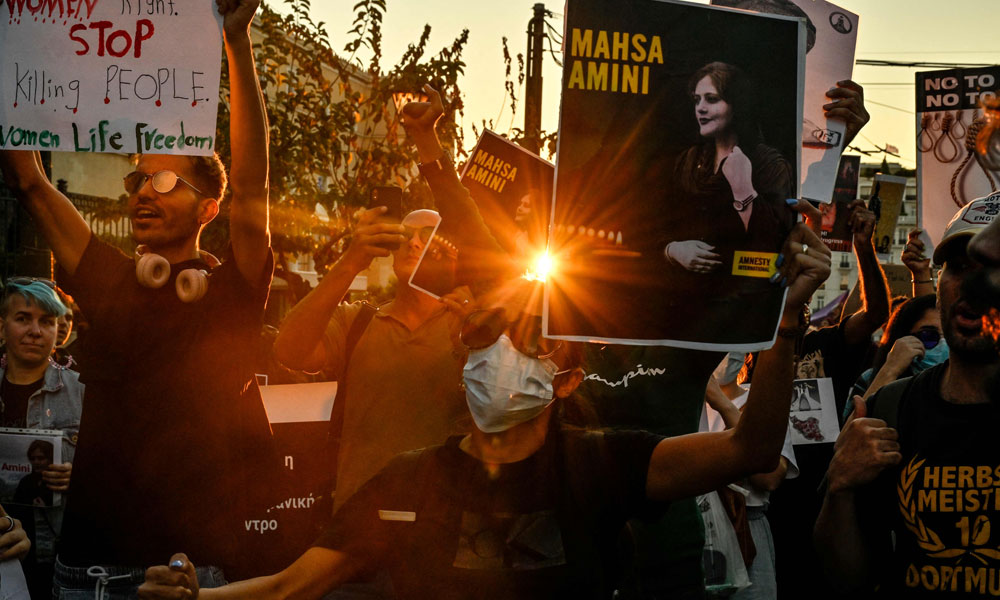 A protester holds a portrait of Iranian Mahsa Amini during a demonstration by Iranians living in Greece in central Athens