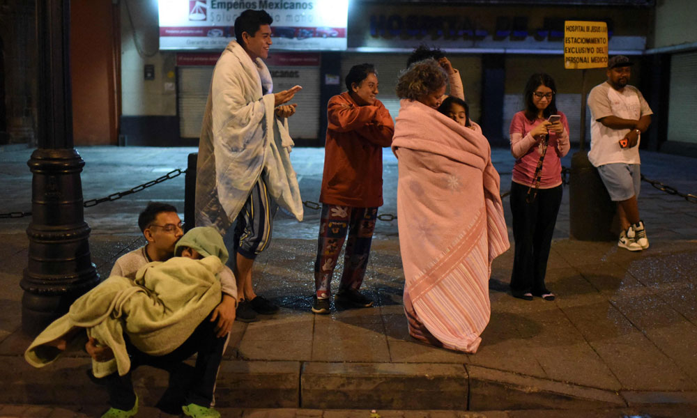 Residents stand in a street after a 6.8-magnitude earthquake in Mexico City on September 22, 2022