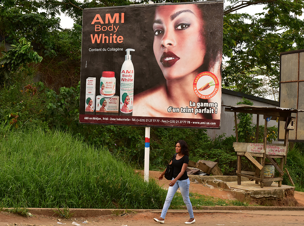 A pedestrian walks past a hoarding advertising a skin-whitening cream on a street in Abidjan. Many African countries including Ivory Coast have banned the use of skin-lightening products because of health concerns. - AFP photos