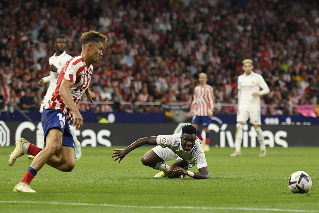 MADRID: Atletico Madrid's Spanish midfielder Marcos Llorente (left) vies with Real Madrid's Brazilian forward Vinicius Junior during the Spanish League football match between Club Atletico de Madrid and Real Madrid CF on September 18, 2022. - AFP