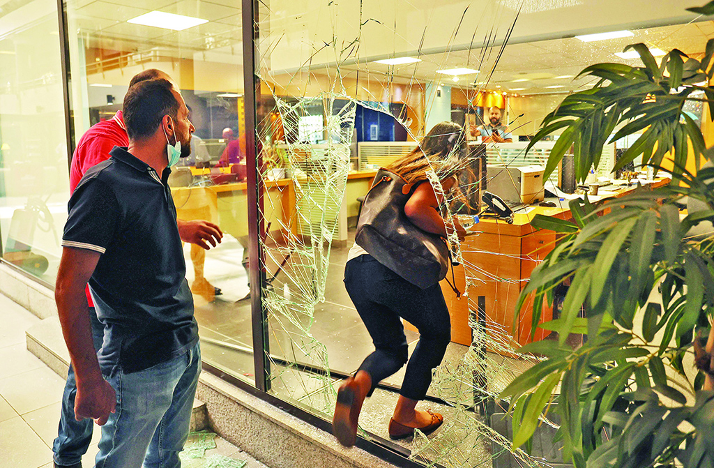 BEIRUT: The glass facade of a bank is broken after a woman stormed it demanding access to her sister's deposits on Sept 14, 2022. - AFP