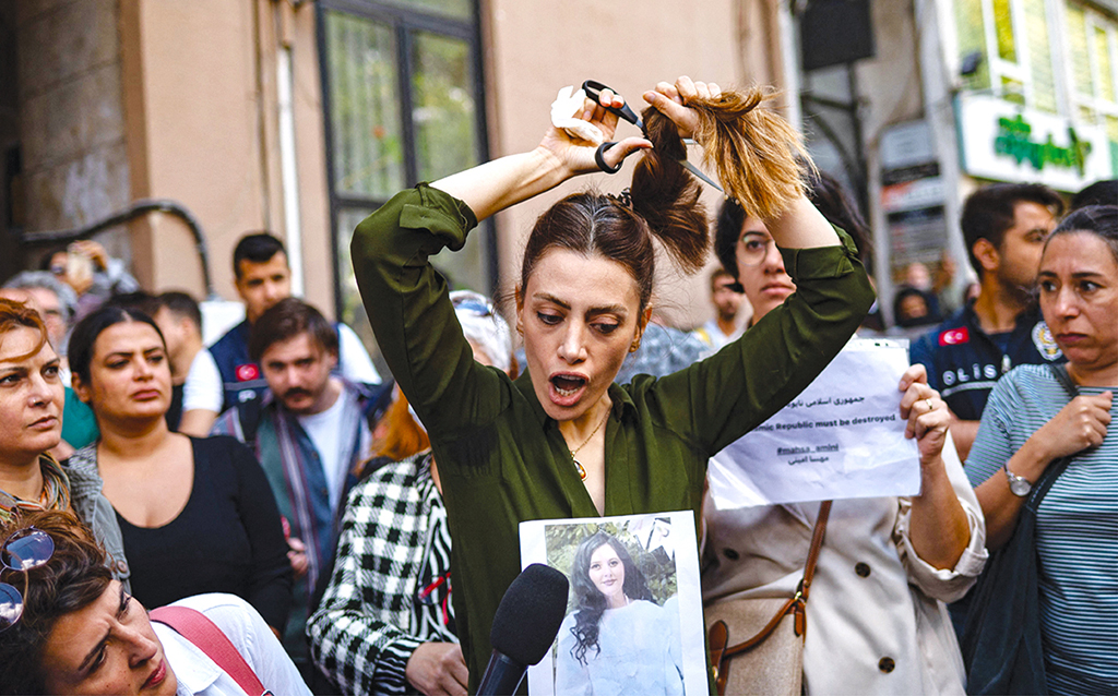 ISTANBUL: Nasibe Samsaei, an Iranian woman living in Turkey, cuts her ponytail off during a protest outside the Iranian consulate on Sept 21, 2022. - AFP