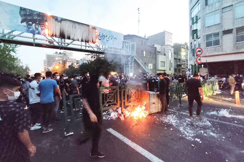 TEHRAN: Iranian demonstrators burn a rubbish bin in the capital on Sept 21, 2022 during a protest for Mahsa Amini, days after she died in police custody. - AFP