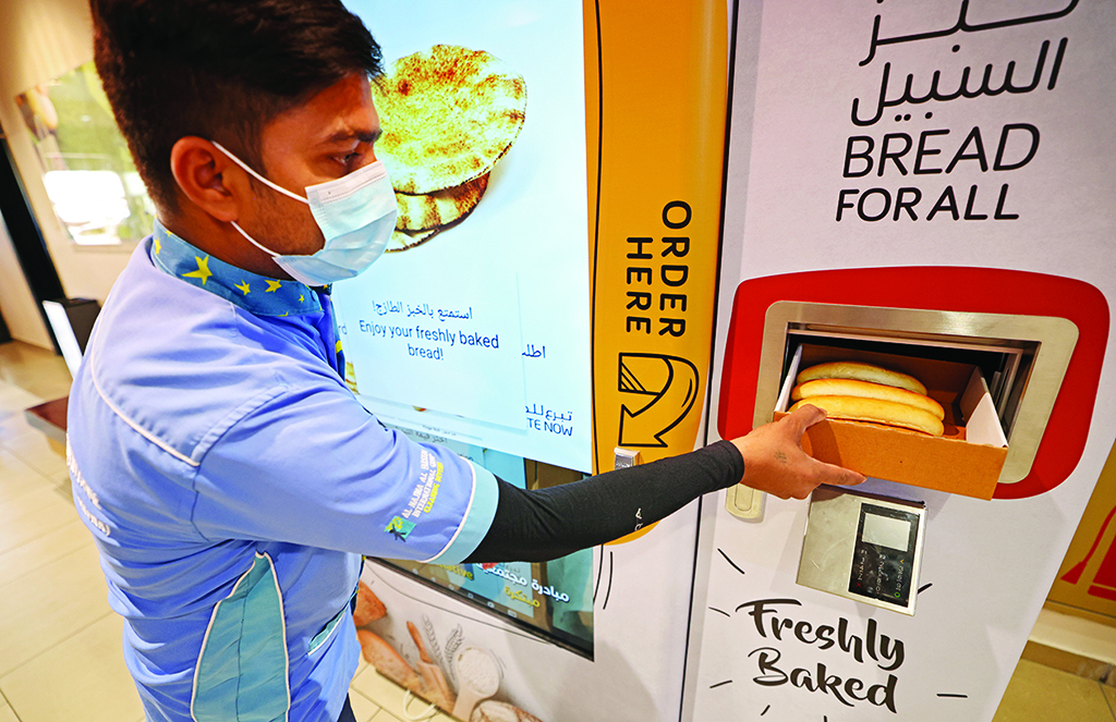 DUBAI: A man collects items from a vending machine that gives out free bread on Sept 22, 2022. - AFP photos
