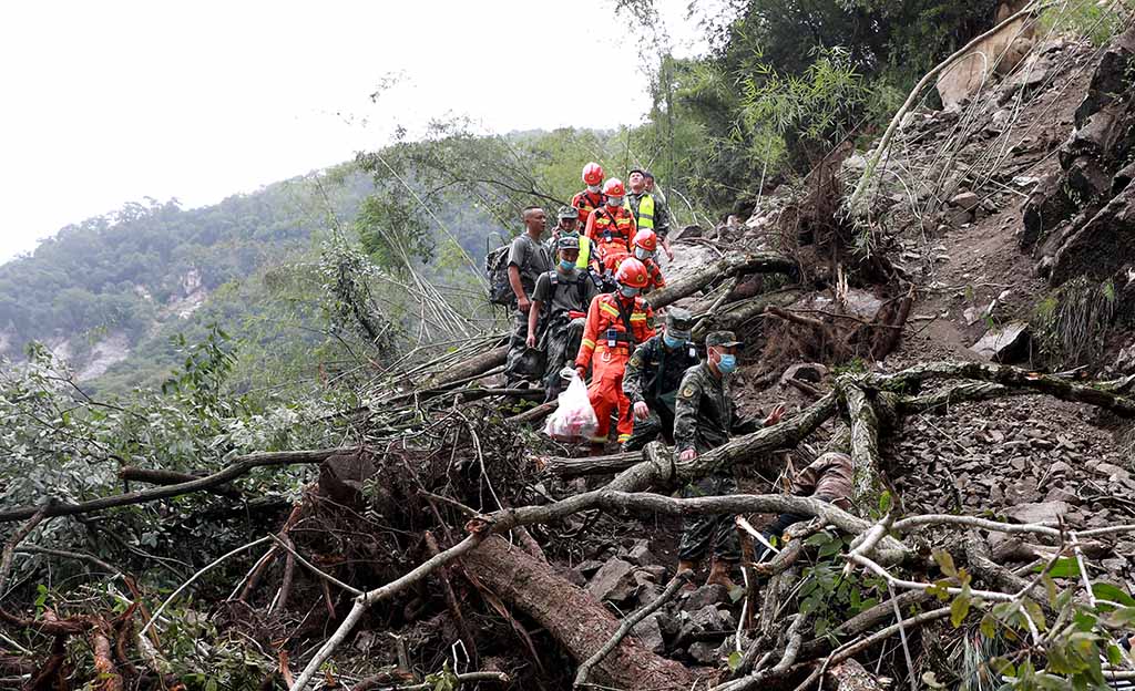 SICHUAN: Rescuers walk past uprooted trees from a landslide as they head to an earthquake-affected area following a 6.6-magnitude earthquake that struck Shimian county, Ya’an city, in China’s southwestern Sichuan province. – AFP