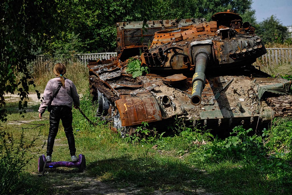 A teenager rides a hoverboard past a destroyed Russian army tank in Lukashivka village in Chernihiv region on Sept 7, 2022 amid the Russian invasion of Ukraine. - AFP photos