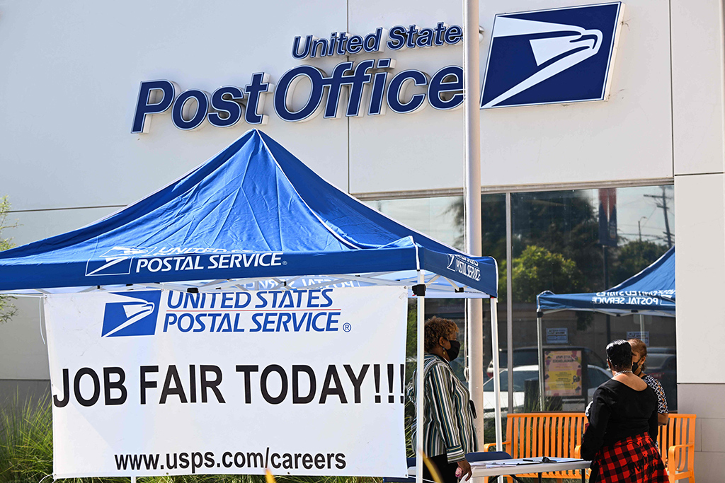 CALIFORNIA: A person receives employment information during a job fair hiring new postal workers and mail carrier assistants at a US Postal Service in Inglewood, California. - AFP