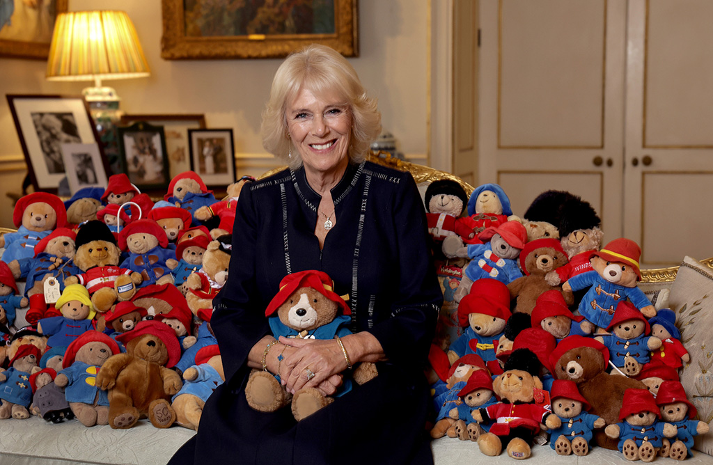 A Buckingham Palace handout image shows Britain's Camilla, Queen Consort posing with a collection of Paddington teddy bears in the Morning Room at the Clarence House, in London.— AFP