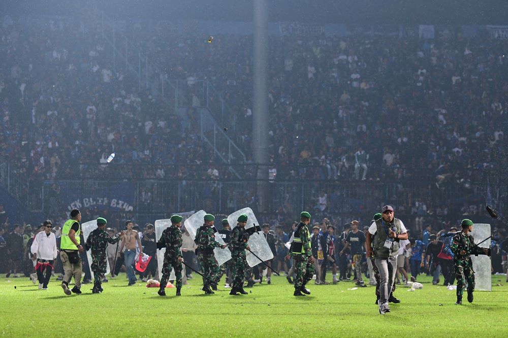 MALANG: This picture taken on October 1, 2022 shows members of the Indonesian army securing the pitch after a football match between Arema FC and Persebaya Surabaya at Kanjuruhan stadium in Malang, East Java. - AFP