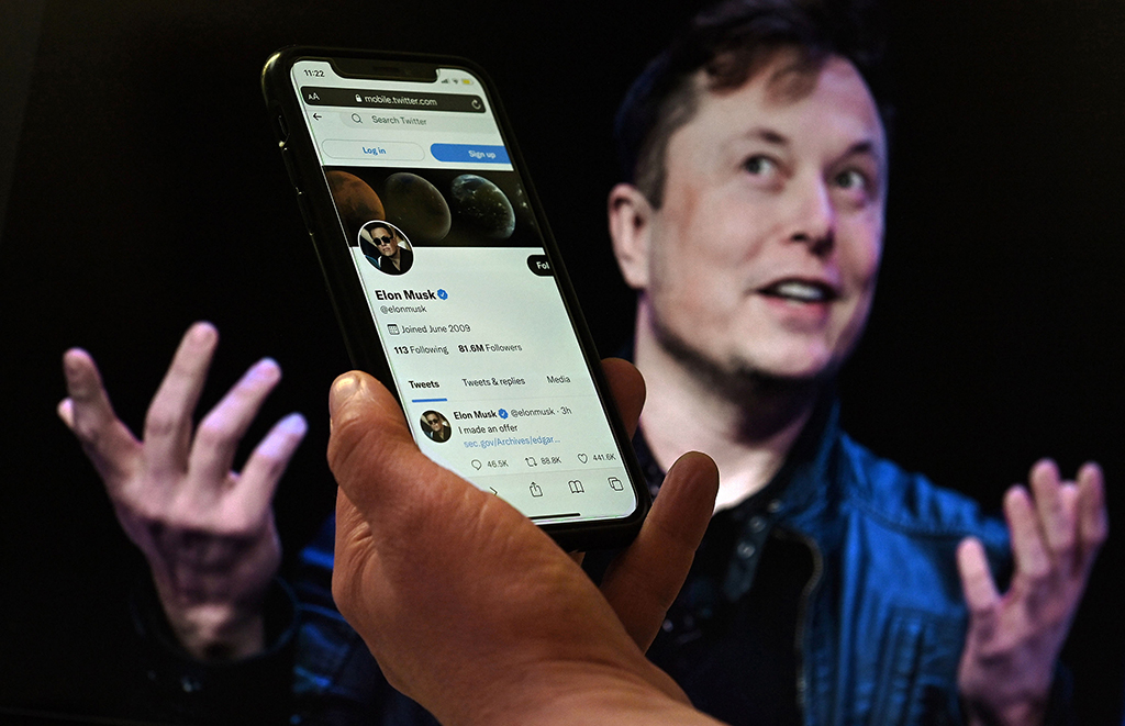 WASHINGTON, US: In this file photo illustration, a phone screen displays the Twitter account of Elon Musk with a photo of him shown in the background, in Washington, DC.- AFP