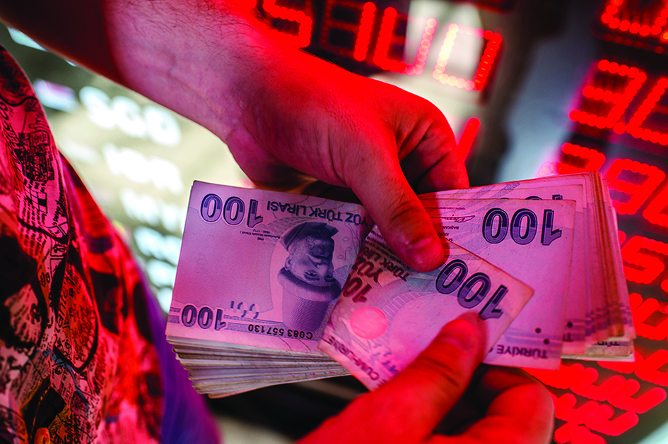 ISTANBUL: A money changer counts Turkish lira banknotes at a currency exchange office in Istanbul. – AFP