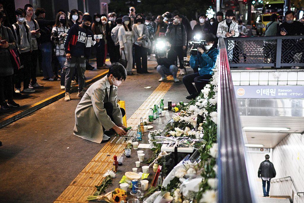 SEOUL: A man pours a glass of beverage, in tribute to those who were killed in a Halloween stampede late on October 29, in the district of Itaewon in Seoul on October 30, 2022. - AFP